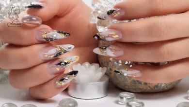 Elegant acrylic nails decorated with black, gold flakes, and gems showcasing acrylic gem durability and long-lasting shine.